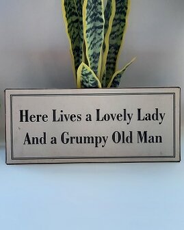 Metalen bord, here lives a lovely lady and a grumpy old man