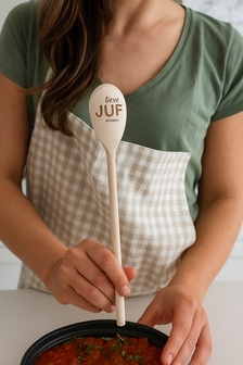 Juf die de lepel met tekst vasthoud