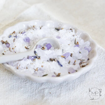 Close up van grove zoutkristallen gemengd met paarse gedroogde lavendel