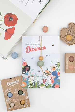 Gelukspoppetje op kaartje met tekst &ldquo;Geluk is een tuintje vol bloemen&rdquo;