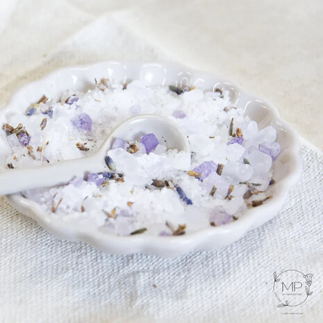 Close up van grove zoutkristallen gemengd met paarse gedroogde lavendel