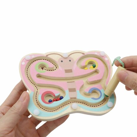 Kind dat balletjes door de vlindervleugels navigeert met het magneetstokje