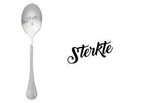Sfeerbeeld van de lepel Sterkte naast een warme kop thee op tafel
