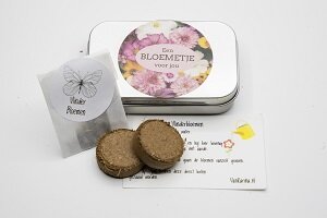 Geopend kweeksetje vlinderbloemen met twee aarde tabletten en zaadjes