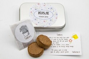 Geopend tuinkers kweeksetje met twee aarde tabletten en zaadjes