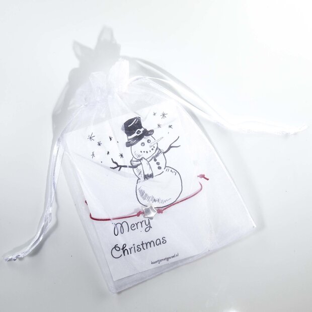 Detailopname van het rode armbandje met zilverkleurige ster op het kerstkaartje